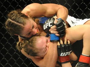 Liz Carmouche grabs hold of Ronda Rousey in the very first female bout inside the UFC octagon.