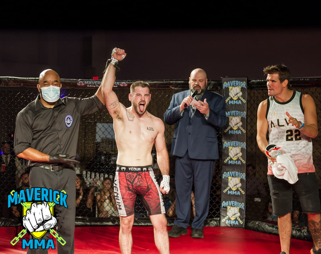 Mickey Gall (far right) claps as Brett Floyd's hand is raised in victory at Maverick 17 - Photo by William McKee