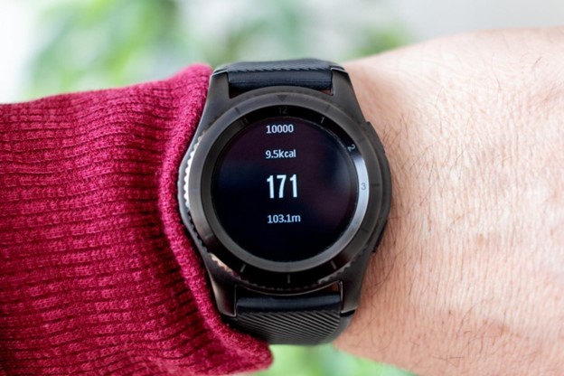 Man examining fitness bracelet, checking calories burned, burn caloriies