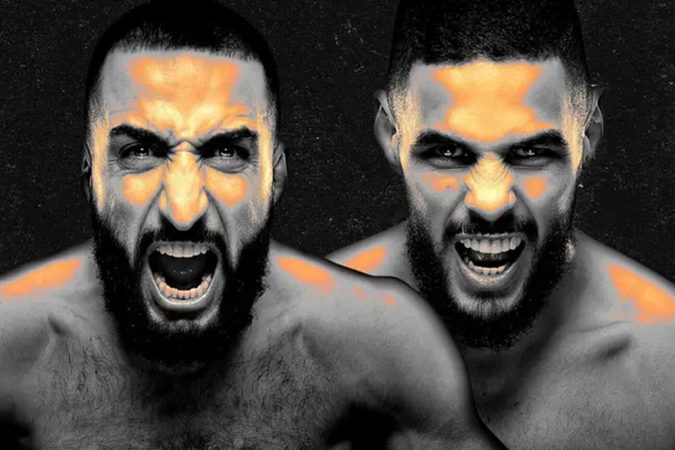 Two shirtless men with beards yell directly at the camera, orange highlights on their faces and shoulders against a dark background.
